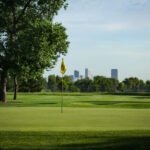 View of the Flag on the 8th Green with City Skyline in the Background
